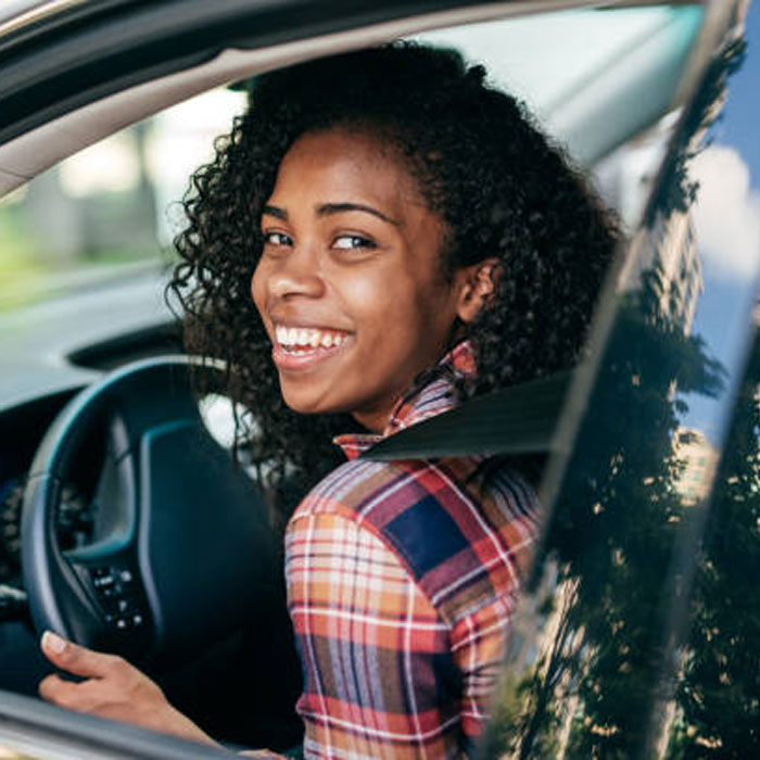 Teen smiling driving a car